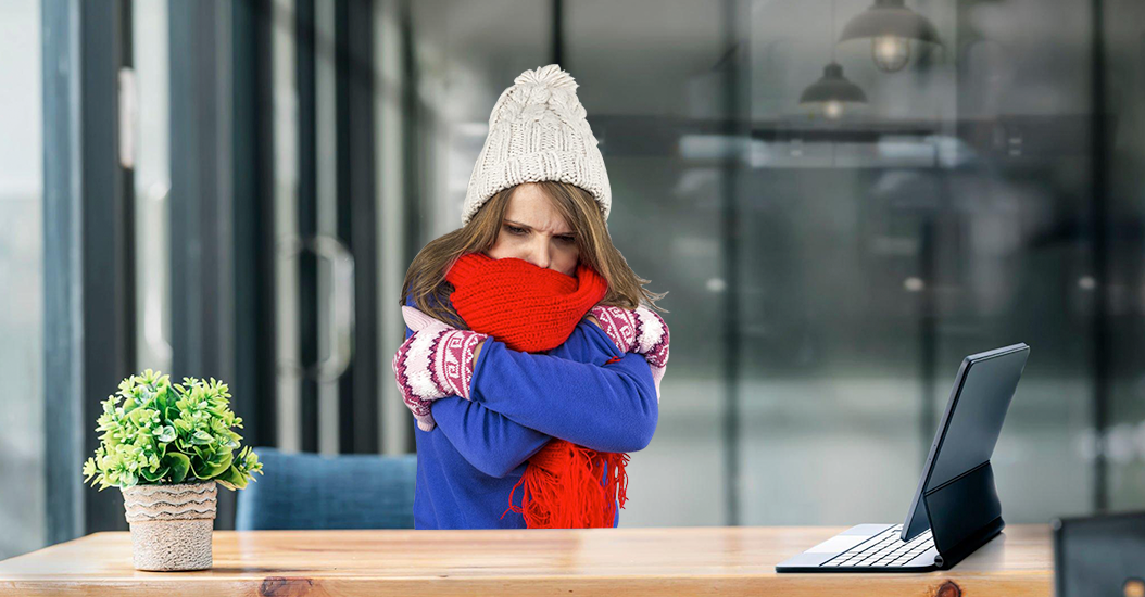 Freezing woman at her desk